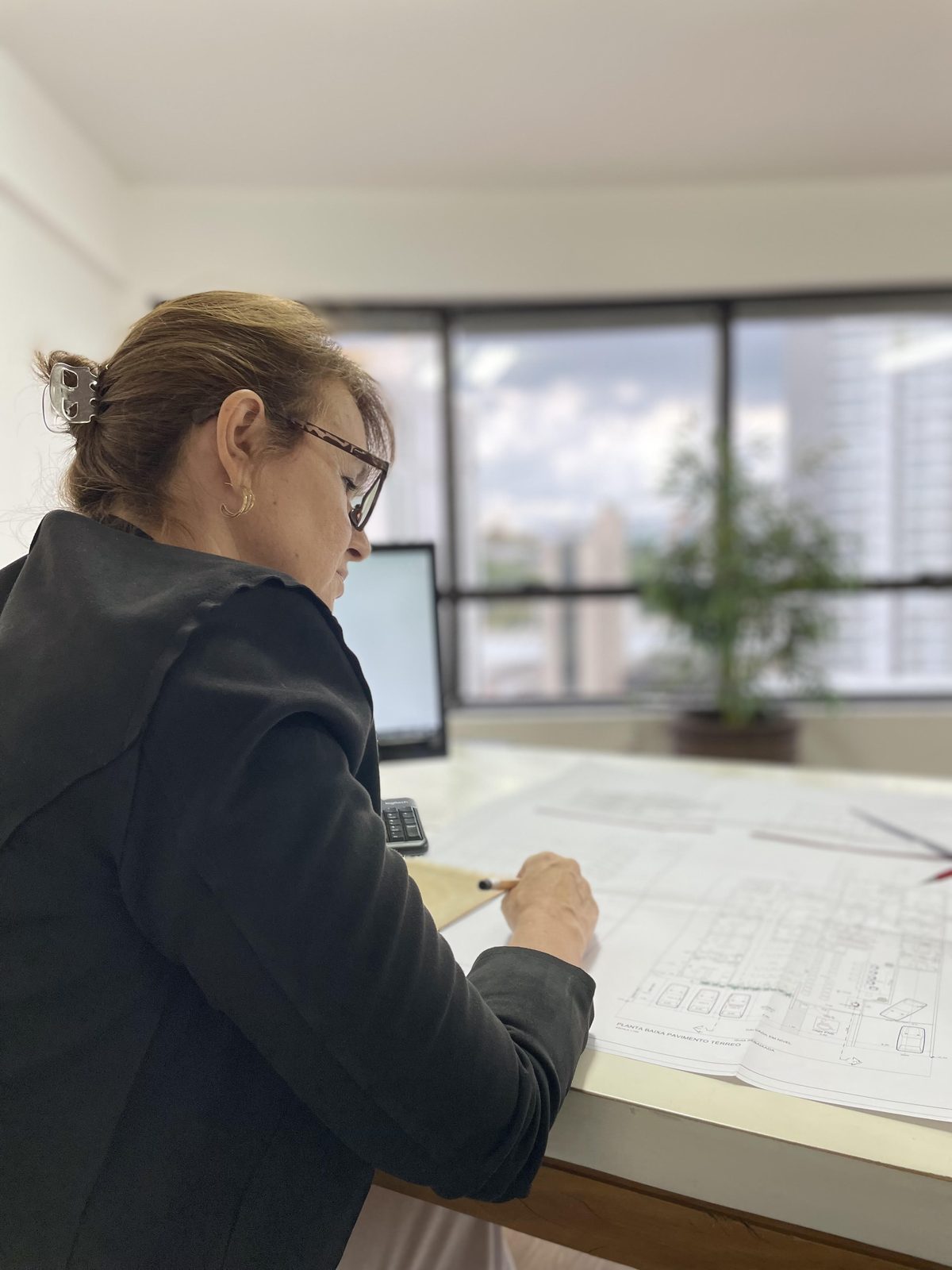 Fabiana Ayres Freire analisando planta arquitetônica